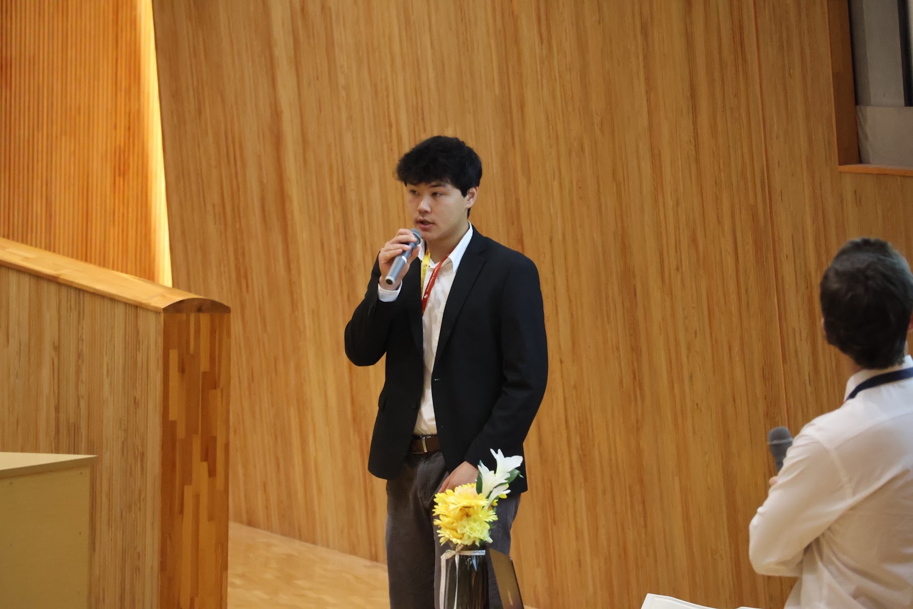 壇上でプレゼンテーションを行う学生
